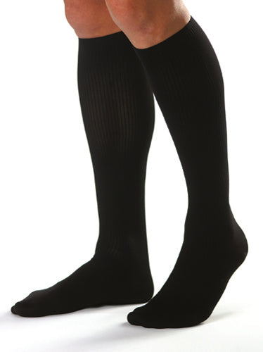 men knee high compression socks 30-40 mmHg large in black worn by a person standing.